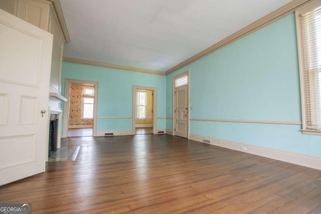 315 Dixie St, Carrollton, GA 30117 - unfurnished living room featuring baseboards, crown molding, a fireplace with flush hearth, visible vents, and wood finished floors