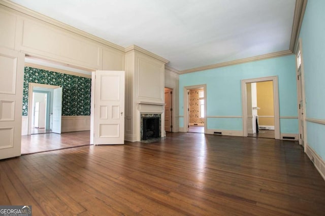 unfurnished living room featuring ornamental molding, wood-type flooring, and a high end fireplace