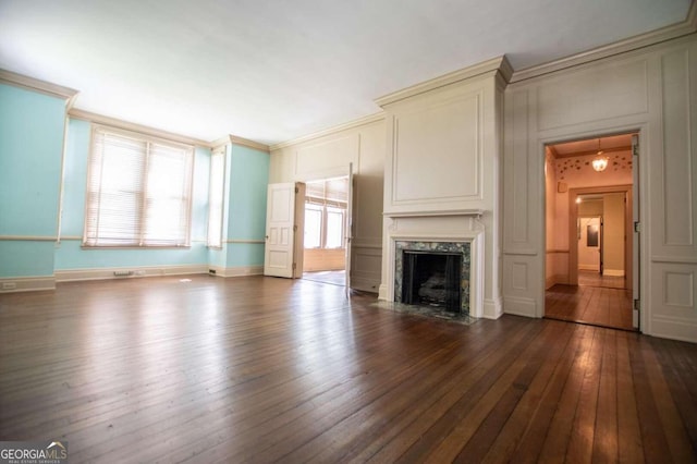 315 Dixie St, Carrollton, GA 30117 - unfurnished living room featuring crown molding, a decorative wall, a fireplace, baseboards, and dark wood-style floors