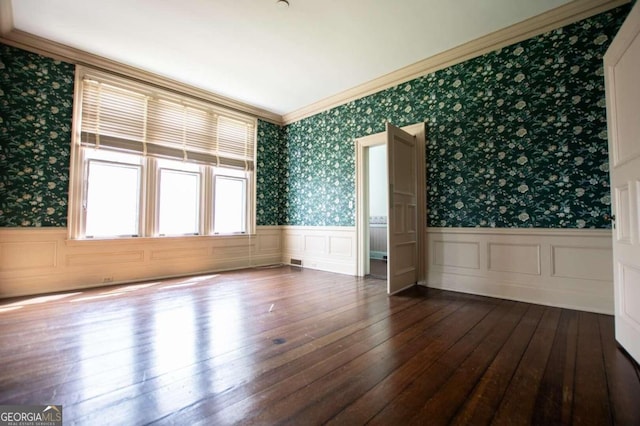 empty room with wood-type flooring and crown molding