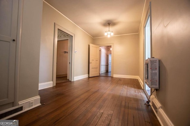 interior space with an inviting chandelier, dark wood-type flooring, and ornamental molding