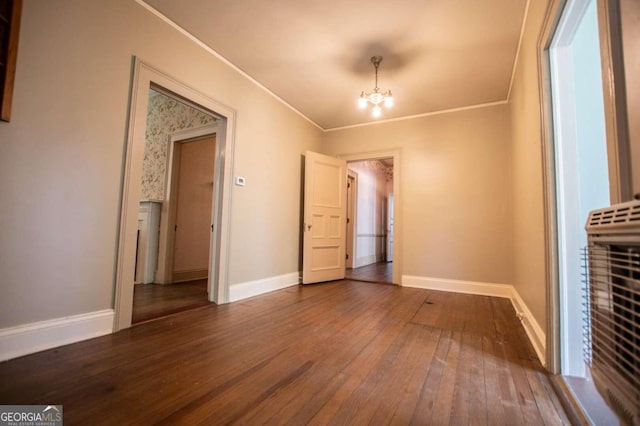 unfurnished bedroom featuring an inviting chandelier, hardwood / wood-style flooring, and ornamental molding