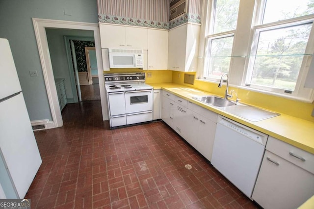 315 Dixie St, Carrollton, GA 30117 - kitchen with brick patterned floor, a sink, light countertops, white appliances, and white cabinetry