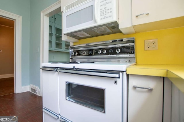 315 Dixie St, Carrollton, GA 30117 - kitchen featuring white appliances, glass insert cabinets, light countertops, brick floor, and baseboards