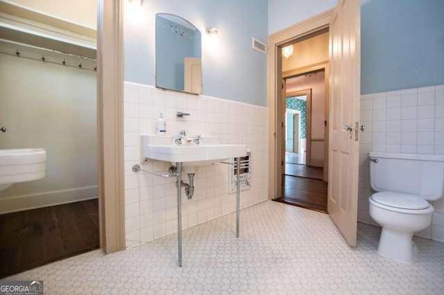 bathroom featuring sink, tile patterned flooring, tile walls, backsplash, and toilet