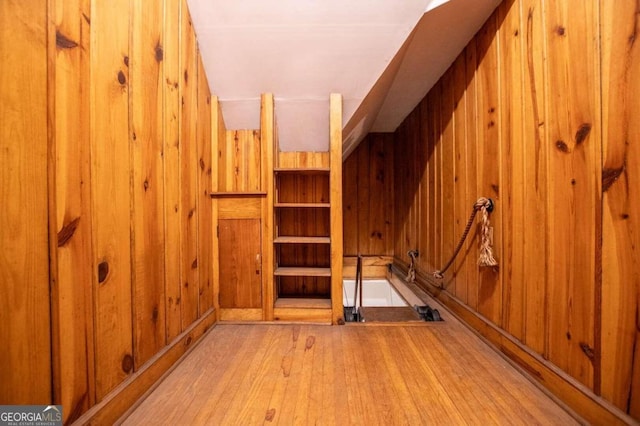 interior space with wooden walls and light hardwood / wood-style flooring