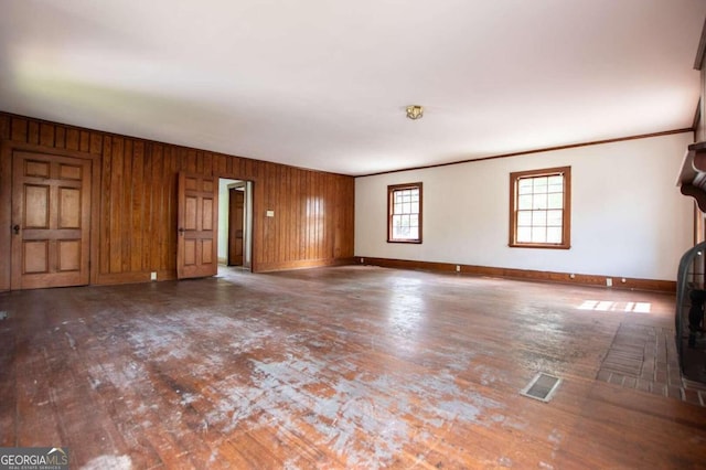 unfurnished living room featuring wood walls