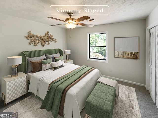 carpeted bedroom with a closet, ceiling fan, and a textured ceiling