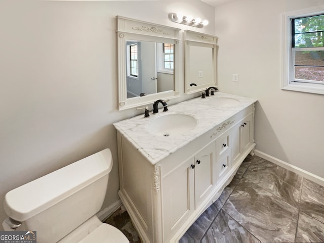 bathroom featuring a wealth of natural light, double sink, oversized vanity, tile flooring, and toilet