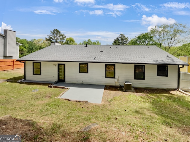 back of property with central AC, a patio area, and a lawn