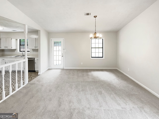 unfurnished living room with sink, a chandelier, and carpet flooring