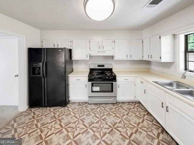 kitchen featuring white cabinets, stainless steel range with gas stovetop, and black refrigerator with ice dispenser