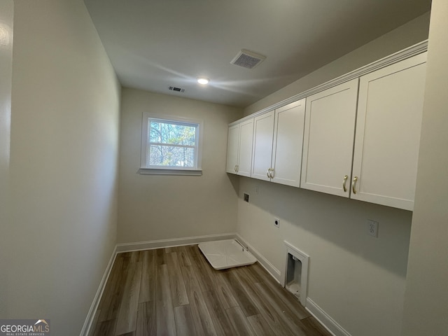 laundry area featuring cabinets, hardwood / wood-style flooring, and electric dryer hookup