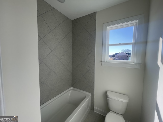 bathroom featuring a washtub, tile patterned flooring, and toilet