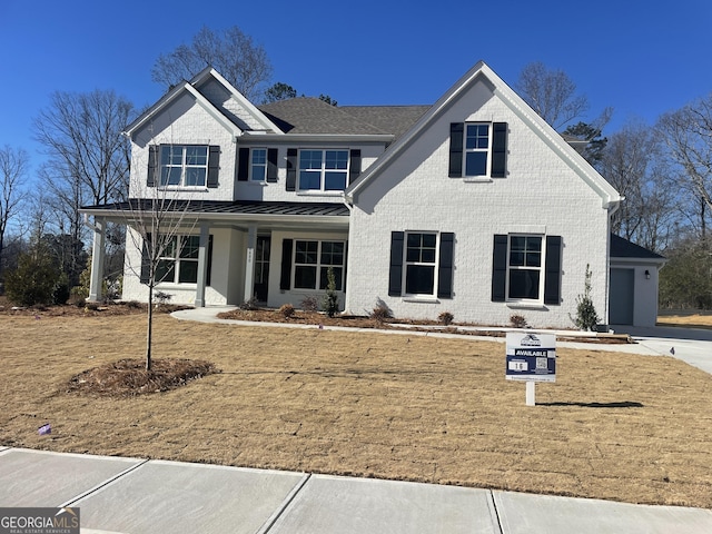 view of front of house featuring a porch, a garage, and a front yard