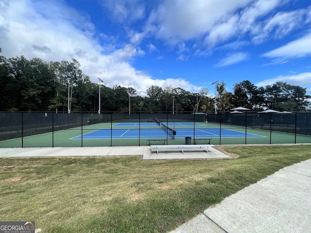 view of tennis court featuring a yard