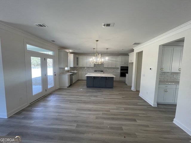 kitchen with white cabinets, pendant lighting, a center island, and decorative backsplash