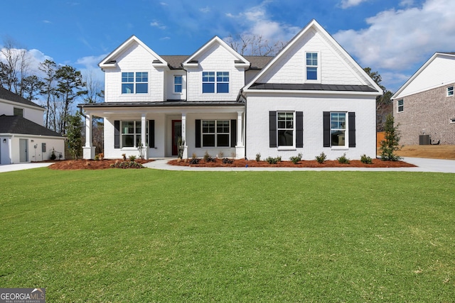 craftsman-style house featuring a porch, a front yard, a standing seam roof, and central air condition unit