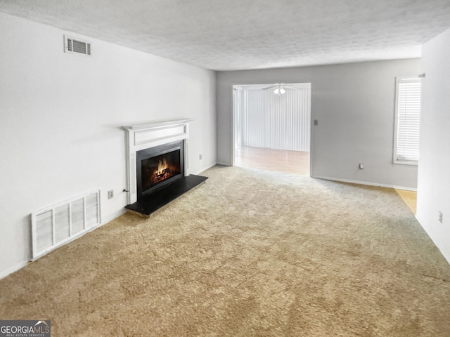 unfurnished living room with a textured ceiling and carpet floors