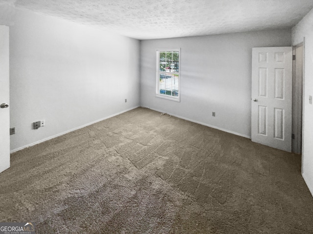 carpeted spare room with a textured ceiling