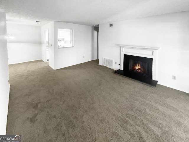 unfurnished living room featuring dark carpet