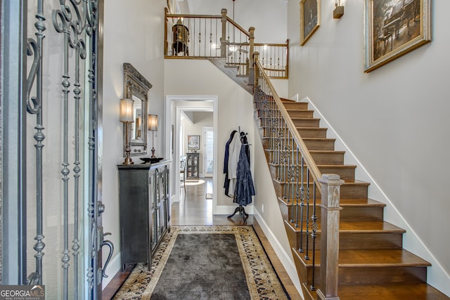 foyer entrance featuring hardwood / wood-style flooring and a towering ceiling