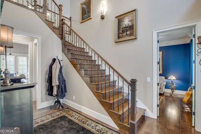 stairway featuring ornamental molding and wood-type flooring