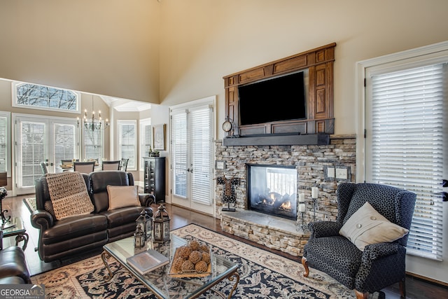 living room featuring hardwood / wood-style flooring, a fireplace, a wealth of natural light, and an inviting chandelier