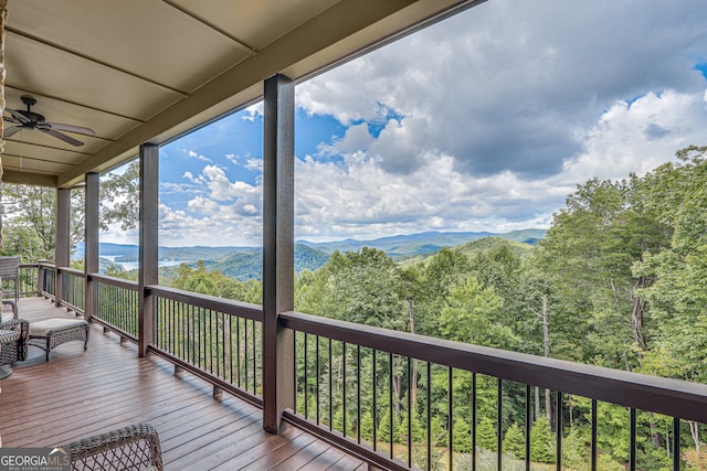 wooden terrace with a mountain view and ceiling fan