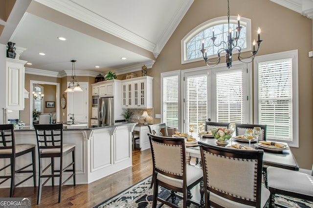 interior space with ornamental molding, vaulted ceiling, a wealth of natural light, and dark wood-type flooring