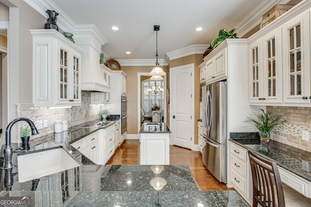 kitchen with sink, decorative light fixtures, stainless steel appliances, tasteful backsplash, and hardwood / wood-style floors