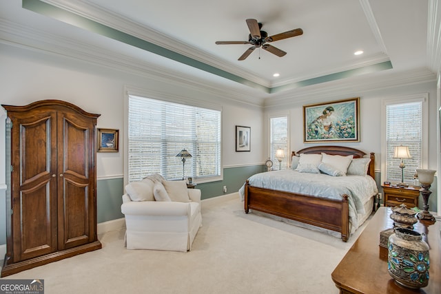 bedroom with ceiling fan, carpet, crown molding, and a tray ceiling