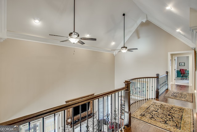 hall with hardwood / wood-style flooring, crown molding, and high vaulted ceiling