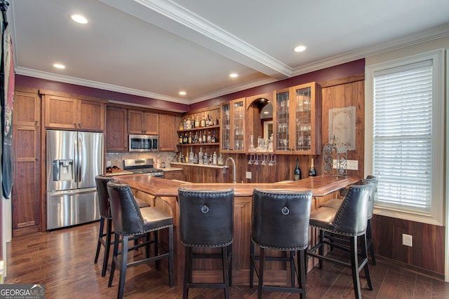 kitchen with kitchen peninsula, stainless steel appliances, dark hardwood / wood-style floors, and a breakfast bar