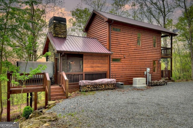 back house at dusk featuring central AC and a deck