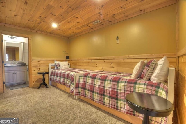 carpeted bedroom with wooden ceiling, sink, and ensuite bathroom