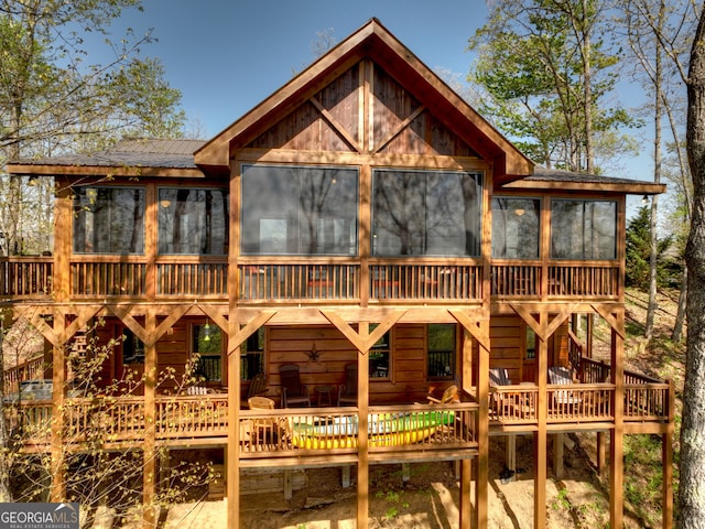 rear view of property with a wooden deck and a sunroom