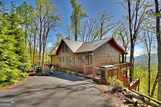 log cabin with a wooden deck