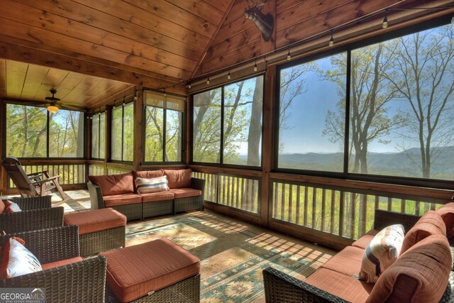 sunroom with vaulted ceiling, ceiling fan, and wooden ceiling