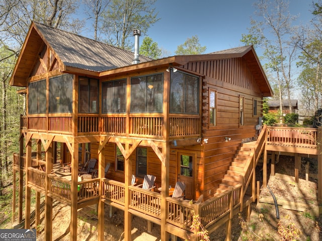 back of house with a deck and a sunroom