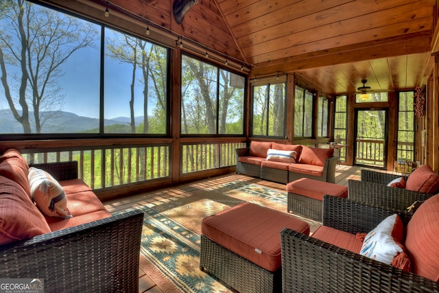 sunroom featuring a wealth of natural light, wooden ceiling, a mountain view, and vaulted ceiling