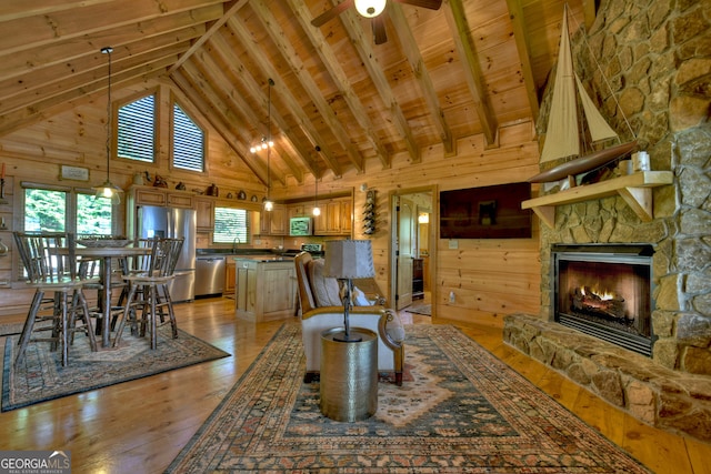 living room with wood ceiling, light hardwood / wood-style flooring, a stone fireplace, and wooden walls