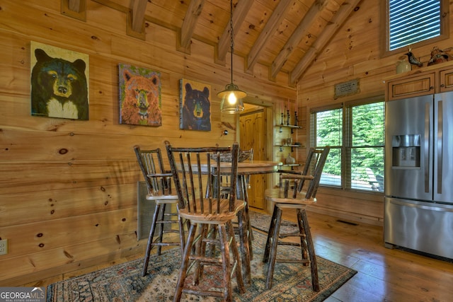 dining area featuring wood-type flooring, wooden walls, and wooden ceiling