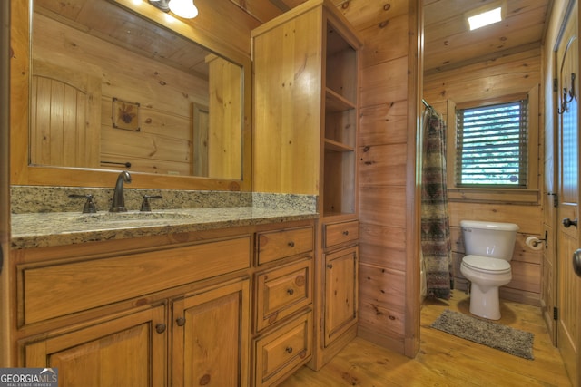 bathroom featuring hardwood / wood-style floors, wooden walls, toilet, wooden ceiling, and vanity