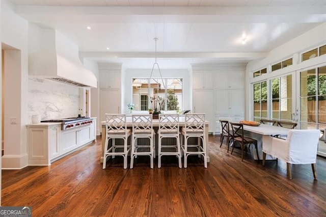 dining room featuring dark hardwood / wood-style floors, beamed ceiling, and a healthy amount of sunlight