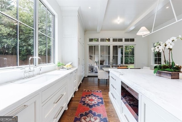 sunroom with beamed ceiling and sink