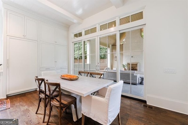 dining space featuring dark hardwood / wood-style flooring and beam ceiling