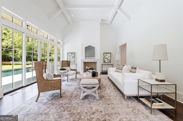 living room featuring light wood-type flooring, high vaulted ceiling, and beam ceiling