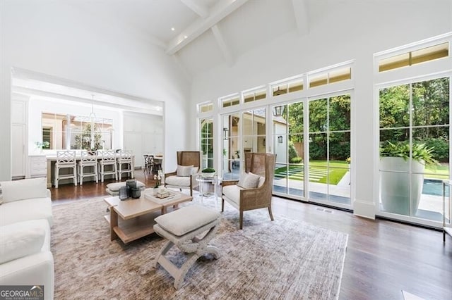 sunroom / solarium featuring a chandelier and vaulted ceiling with beams