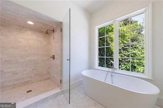 bathroom with plus walk in shower, tile patterned floors, and a healthy amount of sunlight